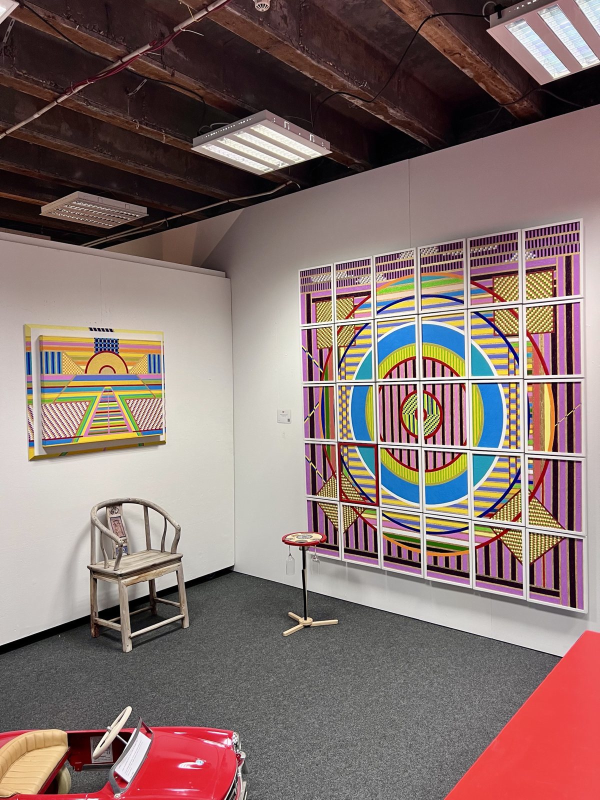 Corner of the gallery with large geometric paintings